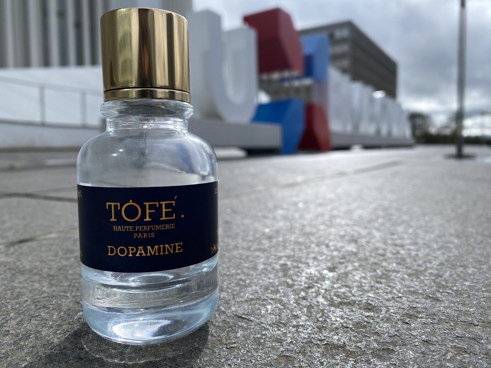 TOFÉ Dopamine eau de parfum bottle with its gold cap and navy label, photographed outdoors